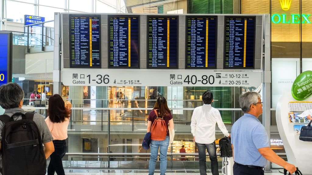 Passengers checking the departure board, how to find cheap flights