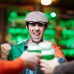 Stag do destinations: group of friends cheering with drinks at a bar
