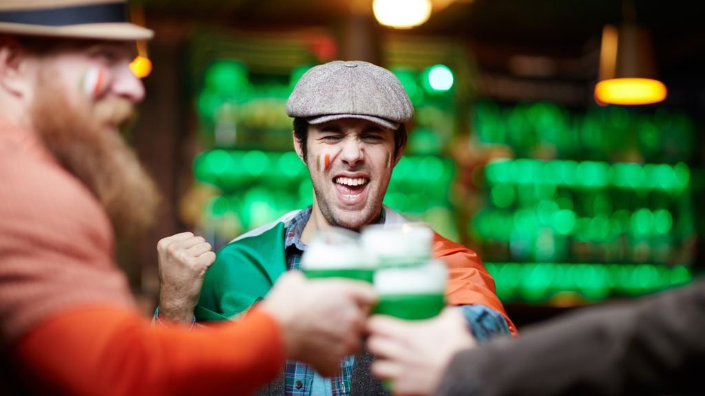 Stag do destinations: group of friends cheering with drinks at a bar